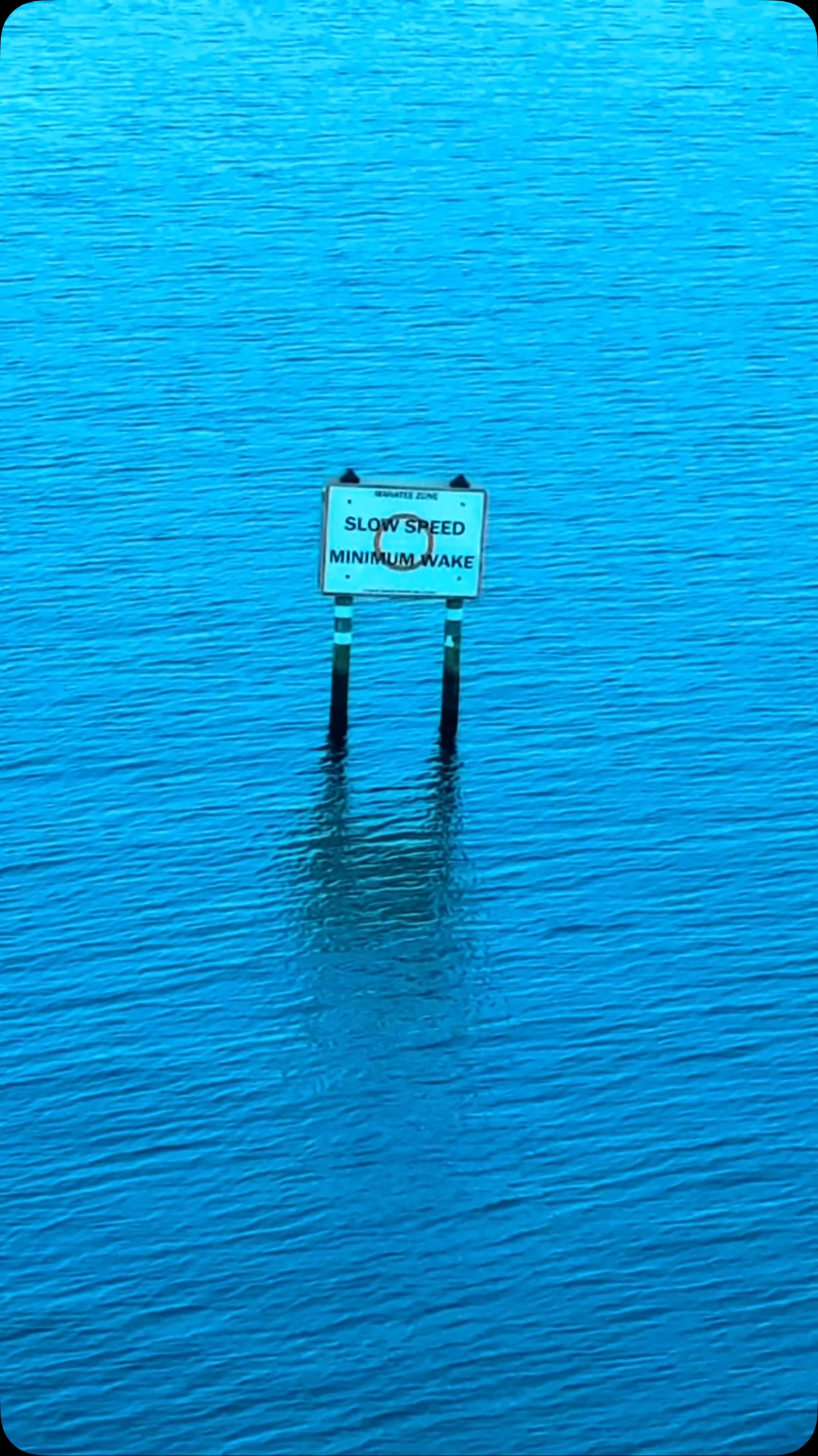 Agua turquesa transparente con postes de señalización desde el aire